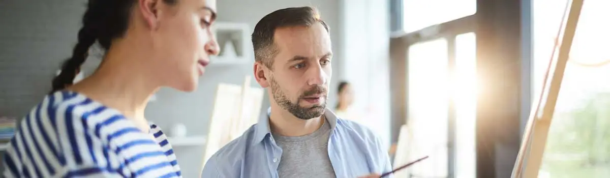 Zwei Menschen diskutieren vor einer Tafel