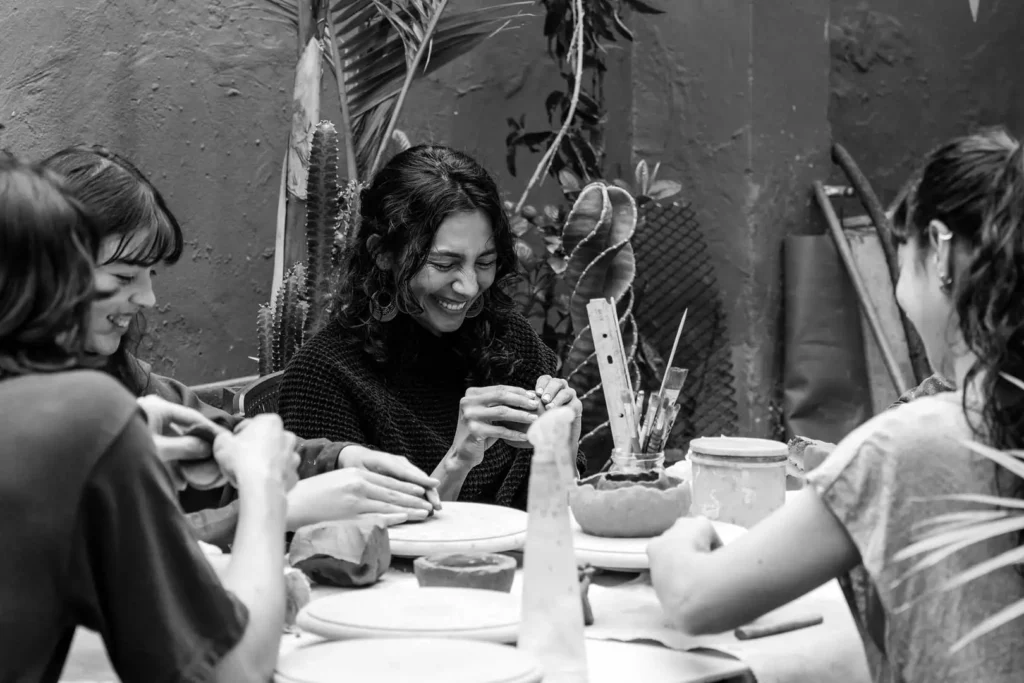 Eine Gruppe von Frauen am Tisch, die handwerklich mit Ton arbeiten
