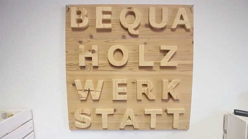 Eine Holztafel mit den Worten: BEQUA HOLZWERKSTATT